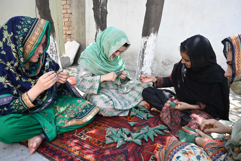 A group of Afghan women creating a seasonal ornament for MADE51. It is a christmas tree decoration.